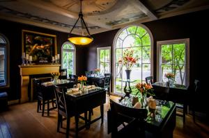 a dining room with tables and chairs and windows at Inn at Parkside in Sacramento