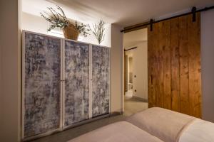1 dormitorio con puerta de madera y 1 cama en New Port Jávea, en Jávea