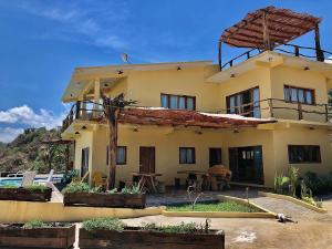 une grande maison jaune avec une table devant elle dans l'établissement Casa Obe, à Yolina