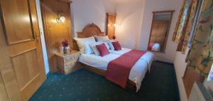 a bedroom with a large bed with white sheets and red pillows at Schlosserhaus Appartements in Wagrain