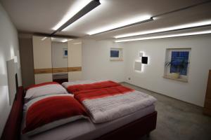 a bedroom with two beds with red blankets at Ferienhaus im Obstgarten in Darlingerode