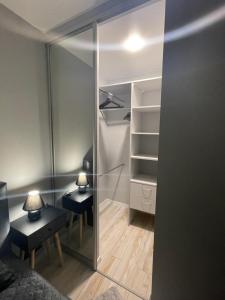 a room with a closet with two tables and a mirror at MB Livinga apartamentai Naftininkų g in Mažeikiai +1 photo