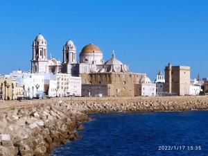 un gran edificio con cúpulas encima junto al agua en Atico Soleado, en Cádiz