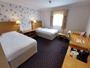 A bed or beds in a room at Chichester Park Hotel