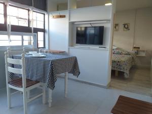 a dining room with a table and a television in a room at CASA BONITA in Ciudad Lujan de Cuyo