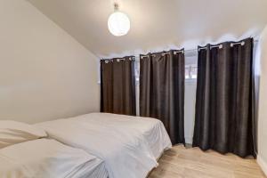 um quarto com uma cama e cortinas pretas em LE NID DOUILLET TOPDESTINATION-BOURG - Centre ville - 3 étoiles em Bourg-en-Bresse