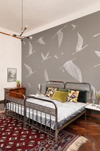 ein Schlafzimmer mit einem Bett mit Vögeln an der Wand in der Unterkunft Anno Budapest 1900 in Budapest