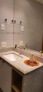 een badkamerbar met een wastafel en een spiegel bij Porto Praia Resort Marulhos in Porto De Galinhas