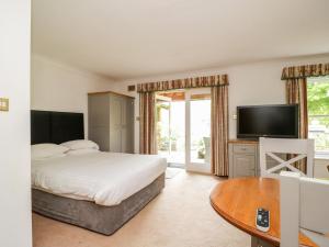 a bedroom with a bed and a tv and a table at Thirlmere Suite in Thirlmere