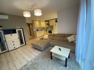 a living room with a couch and a table at Sunny apartment, 5min to the sea. Parking. Self check in. in Palanga
