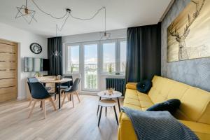 salon z żółtą kanapą i stołem w obiekcie Prime Apartments - Gold Pearl w Gdańsku
