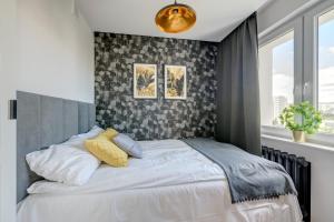 sypialnia z białym łóżkiem ze ścianą w obiekcie Prime Apartments - Gold Pearl w Gdańsku