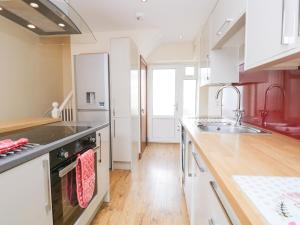 eine Küche mit Spüle und Herd oberen Backofen in der Unterkunft Fernleigh Cottage in Holker