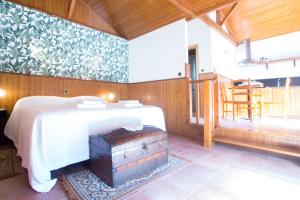 a bedroom with a bed with a wooden wall at Mortazel River Houses in Montazel +121 photos