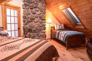 a bedroom with two beds and a stone wall at The Inn at OxBow Acres in Milan