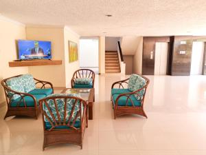 sala de estar con sillas, mesa y TV en Apartamentos Centro IN Rodadero - By Bedviajes, en Santa Marta