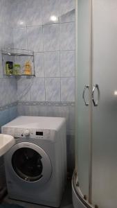 a small bathroom with a washing machine and a sink at Apartments at Laureatov 43 in Noril'sk