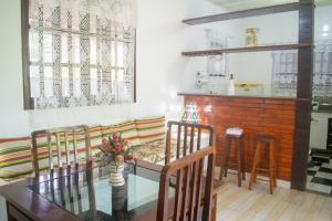 uma sala de jantar com uma mesa de vidro e cadeiras em Casa das Orquídeas em Arraial do Cabo
