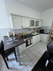 a kitchen with white cabinets and a table with chairs at Apartment BOZ Solingen in Solingen