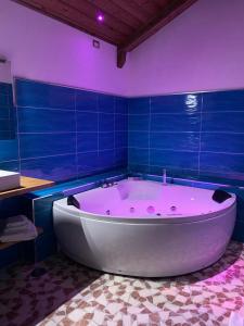 a large bath tub in a bathroom with blue tiles at Setteabbracci Suite & Apartments in Baronissi