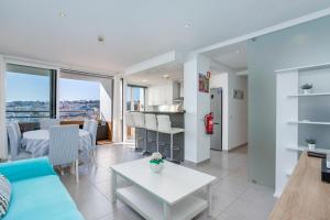 a living room with a blue couch and a table at Clube do Monaco in Albufeira