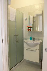 a bathroom with a glass shower and a sink at La terra del sole in Cinisi +28 photos
