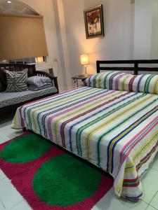 1 dormitorio con 1 cama con un edredón colorido en Will Come Home, en Cebú