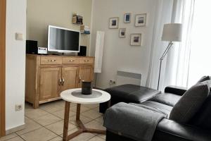 uma sala de estar com um sofá e uma televisão em Apartment Strandidyll, Trassenheide em Trassenheide