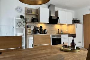 uma cozinha com armários brancos e um balcão de madeira em Apartment Strandidyll, Trassenheide em Trassenheide