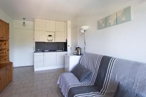 uma sala de estar com um sofá e uma cozinha em Charming Apartment in The City Center With Furnished Terrace pool & Garage em Cagnes-sur-Mer