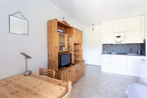 uma cozinha com uma mesa de madeira e uma televisão num quarto em Charming Apartment in The City Center With Furnished Terrace pool & Garage em Cagnes-sur-Mer
