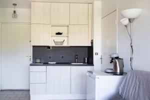 uma cozinha com armários brancos e um lavatório em Charming Apartment in The City Center With Furnished Terrace pool & Garage em Cagnes-sur-Mer