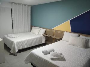 um quarto de hotel com duas camas com toalhas em Pousada Sol e Descanso em Arraial do Cabo