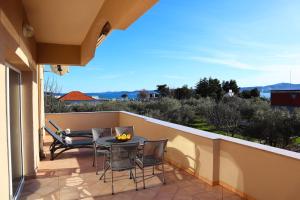 een terras met een tafel en stoelen op een balkon bij APARTMANI VILLA ELVIRA in Sukošan