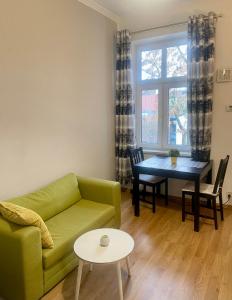 sala de estar con sofá verde y mesa en Luxodonta Apartment, en Cracovia