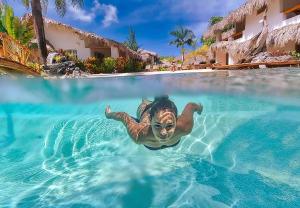 uma sereia a nadar na água num resort em Paradiso del Caribe em Las Galeras