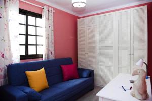 a living room with a blue couch with colorful pillows at Apartment, Los Llanos de Aridane in Los Llanos de Aridane