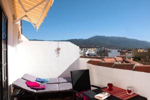 a balcony with a table and chairs on a building at Apartment, Los Llanos de Aridane in Los Llanos de Aridane