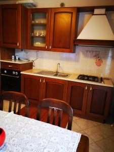 a kitchen with wooden cabinets and a sink and a table at Residence SANTA CROCE Delebio Provincia di Sondrio in Sondrio