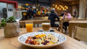 a plate of food on a table with orange juice at Selina Salta in Salta