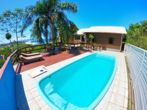 uma piscina num pátio com uma casa em Casa Vista Privilegiada: Piscina e Conforto em Garopaba