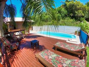 a patio with a hammock and a swimming pool at Casa Vista Privilegiada: Piscina e Conforto in Garopaba +28 photos