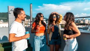 a group of people standing on a rooftop with drinks at Selina Salta in Salta