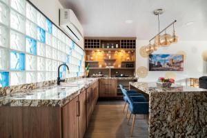 una cocina con una gran isla con sillas azules en Modern, Luxurious and Tradicional Apartments by Samilis Place, en Cali