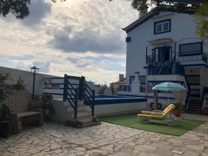 ein Haus mit einem Spielplatz davor in der Unterkunft Villa Praia in São Martinho do Porto