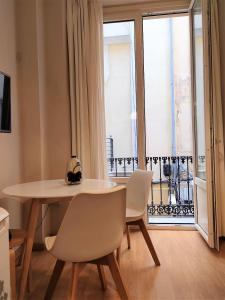 Un comedor con mesa y sillas y una ventana. en Art and Night - City Center Studio, en Málaga