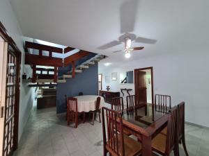 Vila Itanhaém في إيتانهايم: غرفة طعام ومطبخ مع طاولة وكراسي