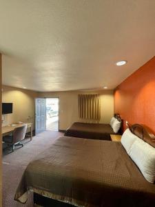 Una habitación de hotel con una cama grande y un escritorio. en Red River Inn, en Clarksville