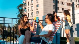 a group of people sitting in lawn chairs on a roof at Selina Salta in Salta