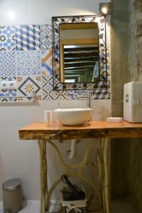 a bathroom with a sink and a mirror on a counter at Casa do Ti Gabriel in Sabugueiro